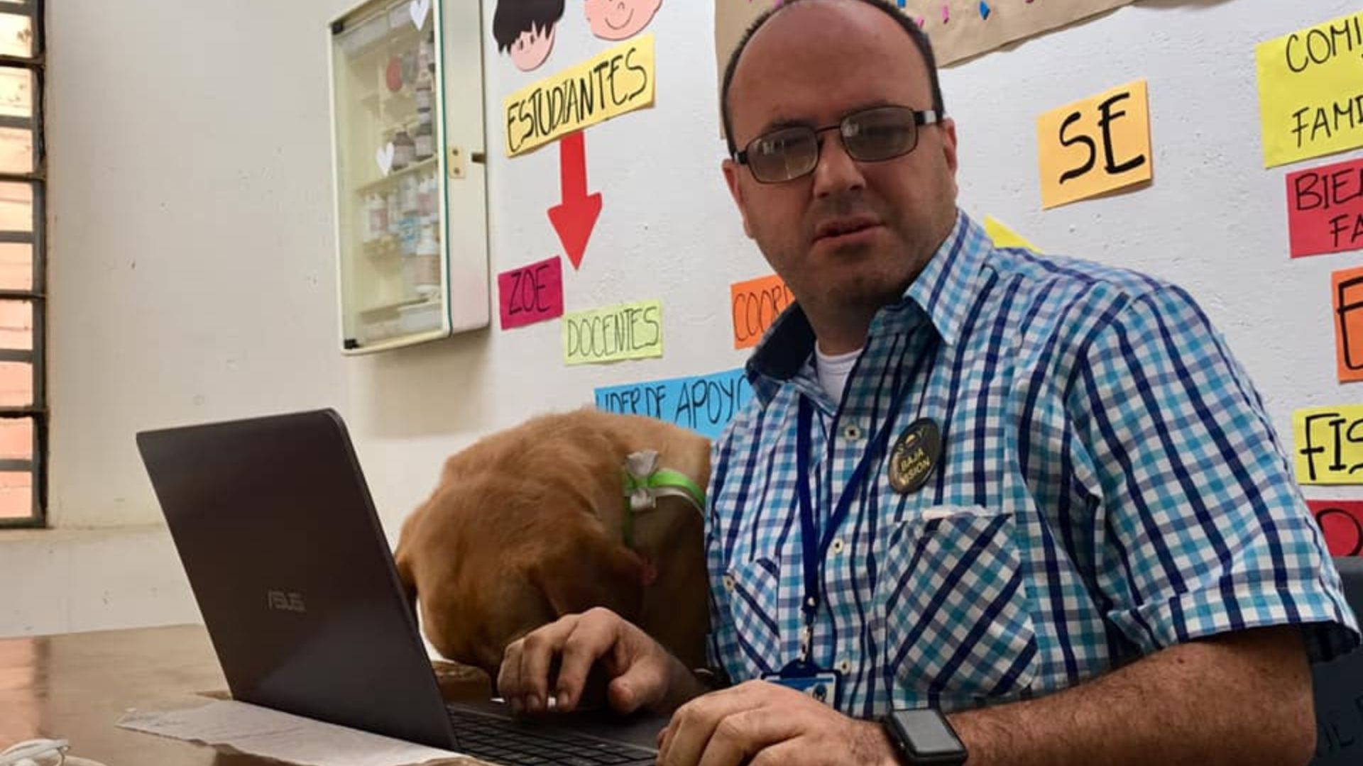 En la fotografía: Hernán Villegas frente a un computador portátil acompañado por su perro lazarillo. En la fotografía: Hernán Villegas frente a un computador portátil acompañado por su perro lazarillo.